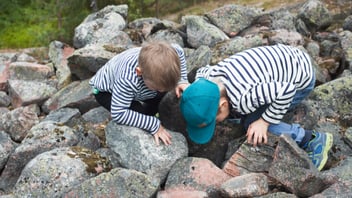 children play outside on a rock site in finland