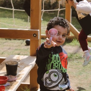 a child plays with dirt and smiles
