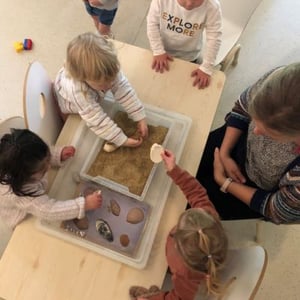 children doing a project with sand and shells