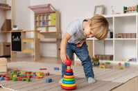 full-shot-kid-playing-floor-with-wooden-toy