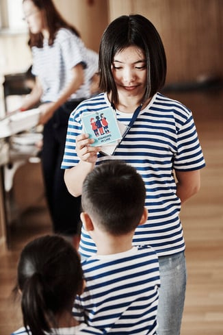 Teacher with HEI Pictogram in hand   Source: HEI Schools