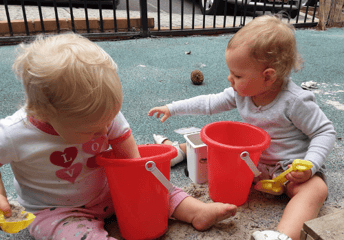 babies with buckets in a sensory activity