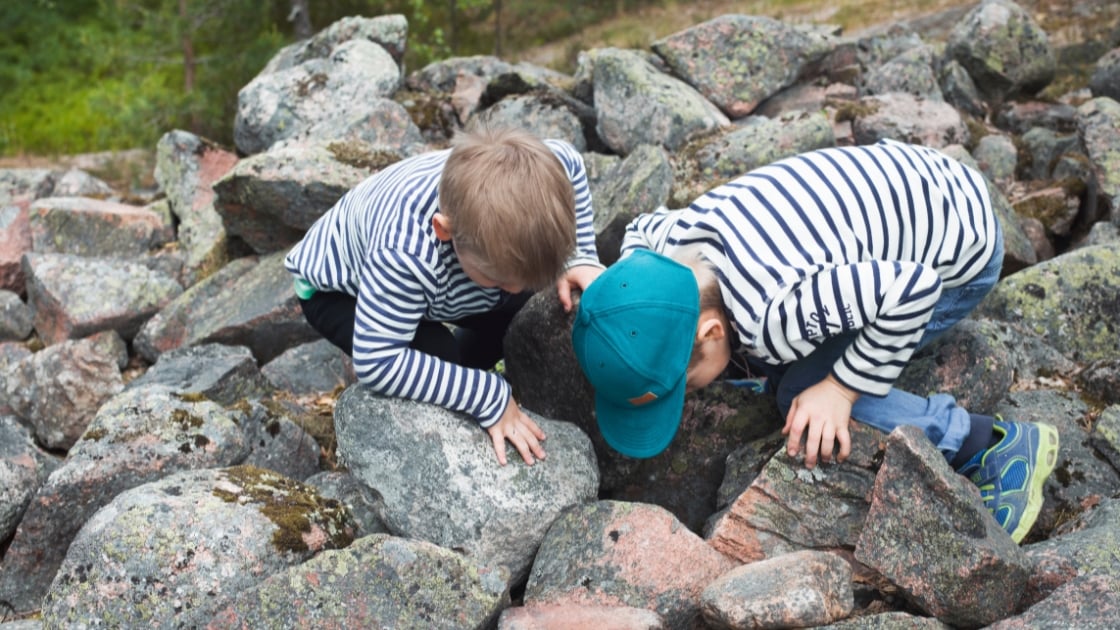 children play outside on a rock site in finland