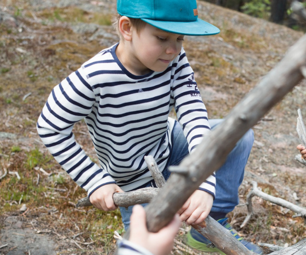 Boy playing with wood 600 x 500